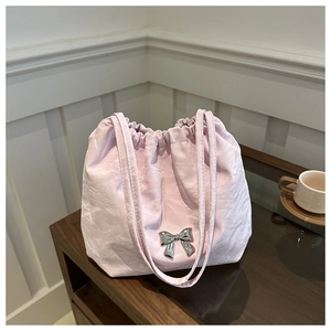 Close-up of lilac pleated tote bag with a silver metallic bow and slim shoulder straps