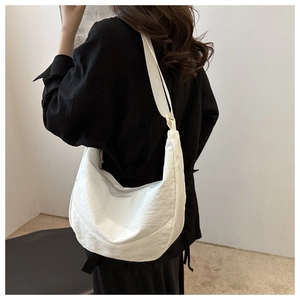 Achteraanzicht van een witte halvemaanvormige crossbodytas met verstelbare riem