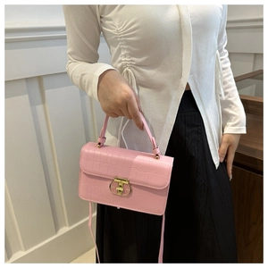 Piccola borsa quadrata rosa effetto coccodrillo con chiusura girevole dorata su modella