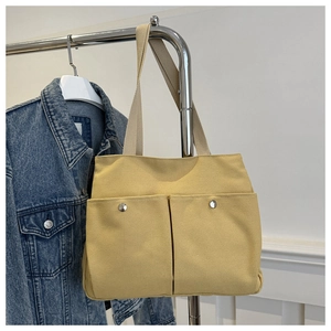 Large yellow canvas tote bag with double front flap pockets and silver metal buttons