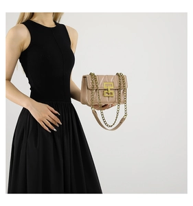 Détail du sac matelassé rose nude avec texture en V et boucle métallique dorée entrelacée