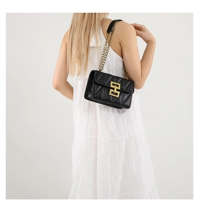 Détail d'un sac bandoulière en cuir matelassé noir avec chaîne dorée et fermoir