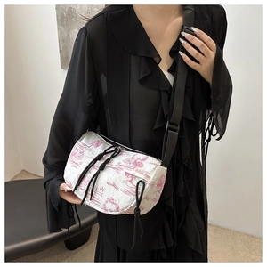 Detail showing pink landscape pattern and black drawstring on the nylon crossbody bag