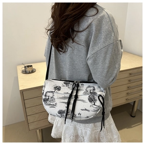 Detail of artistic landscape print on elegant underarm bag with black shoulder strap