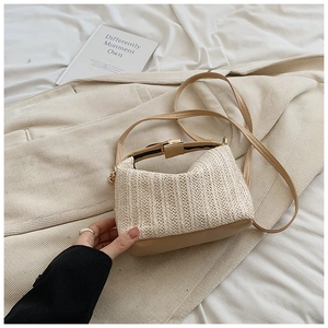 Détail d'un sac à main en paille tissée avec base en cuir et fermoir métallique