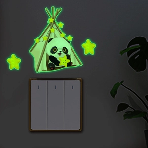 Luminous panda and stars wall sticker glowing green in the dark above a light switch