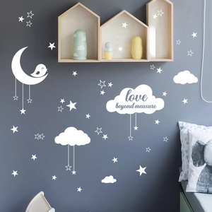 Détail de stickers muraux lune et étoiles blanches avec texte sur un mur gris foncé