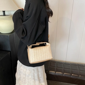 Sac bandoulière chic en paille tressée beige avec finitions en cuir brun et métal doré
