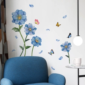 Close-up of blue floral wall stickers with butterflies in a modern living room scene