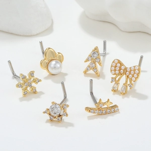 Set of 6 gold L-shaped nose studs featuring snowflake, moon and pearl charm designs