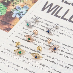 Macro shot of evil eye stud earrings with crystals in gold, silver and rose gold
