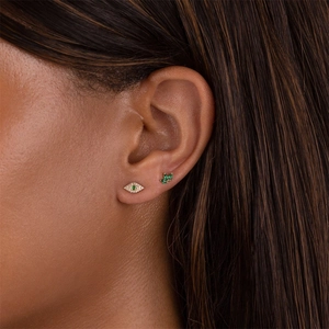 Evil eye and emerald cluster stud earrings set in gold finish on female ear