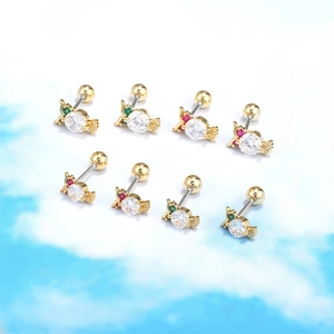 Detail van snoepvormige gouden piercings met heldere kristallen en schroefsluitingen