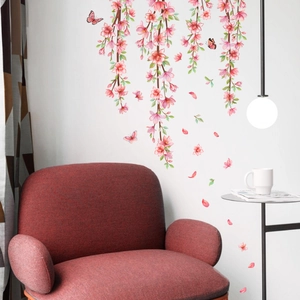 Détail de stickers muraux fleurs de cerisier roses avec papillons sur canapé rouge