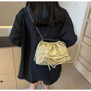 Pistachio green pleated cloud bucket bag with bow details and silver chain strap
