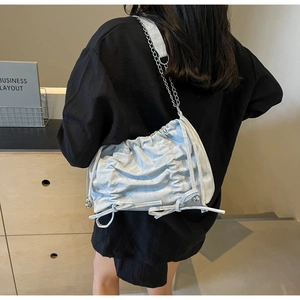 Detail of light blue pleated cloud bag featuring bow drawstring and silver chain strap