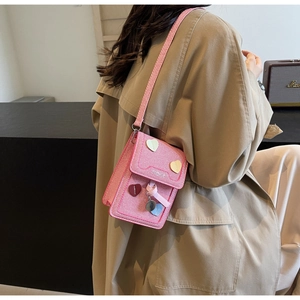 Detailed close-up of a pink woven crossbody bag with cream and burgundy heart patterns
