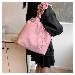 Detail of pink eco-friendly tote bag with pleated handles and silver rhinestone accents