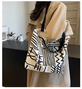 Detail of the large canvas tote bag featuring black and white abstract graffiti prints