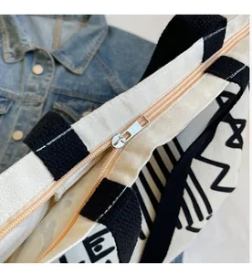 Detailed view of the smooth metal zipper closure on the graffiti canvas tote bag