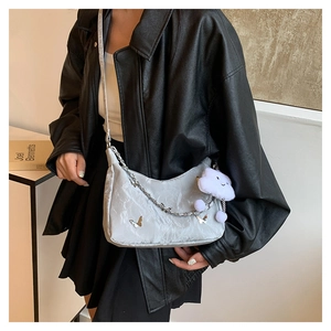 Detail of silver crescent bag featuring marble texture, butterfly chain and cloud charm