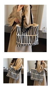 Detail of canvas tote bag with black and white vertical stripes and black straps