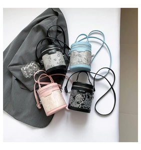 Detail view of mini cylinder bucket bags with embroidery and removable straps