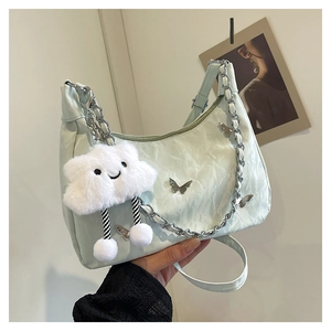 Detail of light green butterfly tote bag featuring pleated texture and silver chain strap
