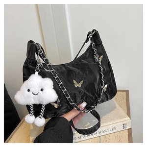 Detail of black pleated hobo bag with silver butterfly charms and white cloud pendant