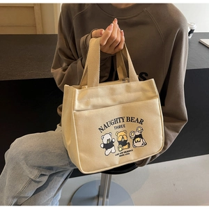 Detail showing the woven canvas texture and naughty bear cartoon print on the tote bag