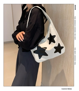 Detailed side view of white nylon shoulder bag featuring a large black star design
