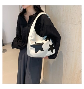 Detail van de witte tote bag met een groot zwart sterpatroon en brede schouderband voor dam