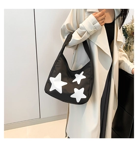 Detail of trendy black nylon shoulder bag with white star print and curved design