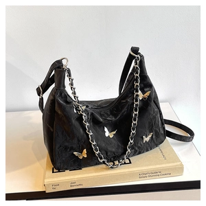 Minimalist black hobo bag with butterfly metallic charms and silver chain strap details