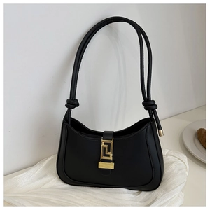 Detail of black leather hobo bag featuring a golden geometric clasp and knotted strap