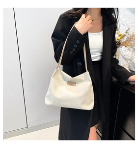 Détail du sac cabas en toile crème montrant la texture rayée et l'empiècement