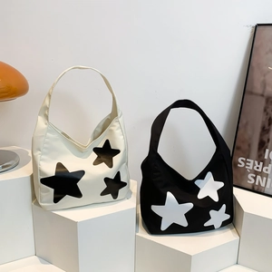 Minimalist canvas tote bags with star patterns displayed on modern geometric pedestals