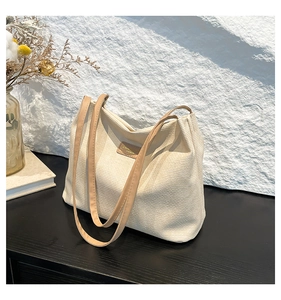 Détails du sac fourre-tout en velours côtelé écru avec fines anses en cuir kaki