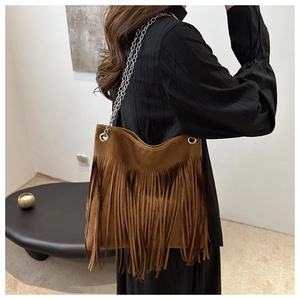 Detail of brown suede tote with long tassels and silver metal chain shoulder strap