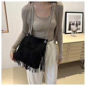 Detail of bohemian black fringe shoulder bag with fine silver chain strap and suede texture