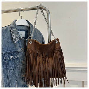 Gros plan du sac cabas en daim marron avec de longues franges et chaîne argentée