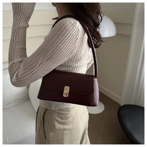 Elegant wine red baguette underarm bag with gold lock buckle and minimalist leather strap