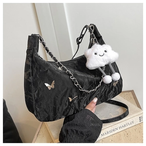 Détail du sac plissé noir avec charmes papillon argentés et pendentif nuage en peluche