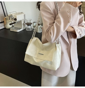 Détail du sac bandoulière en cuir blanc cassé avec ferrures argentées et chaîne