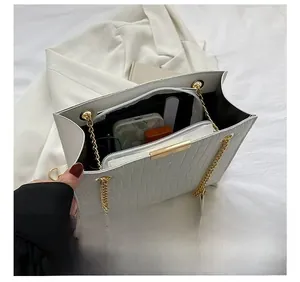 Interior view of white croc-embossed tote bag with multi-layer storage and gold chain