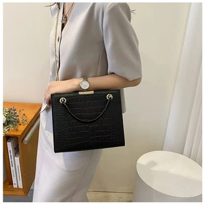 Elegant black crocodile pattern tote bag with gold hardware shown on a model's shoulder