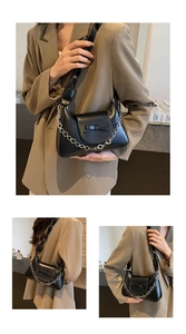 Detailed view of black leather shoulder bag with floral silver chain and bow knot