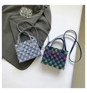 Top view of two plaid denim mini tote bags with frayed edges and golden hardware