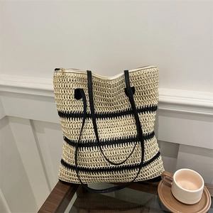 Minimalist straw woven tote bag with black stripes and sleek leather shoulder straps