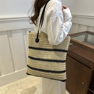 Japanese style striped straw bucket bag with black handles and woven summer texture